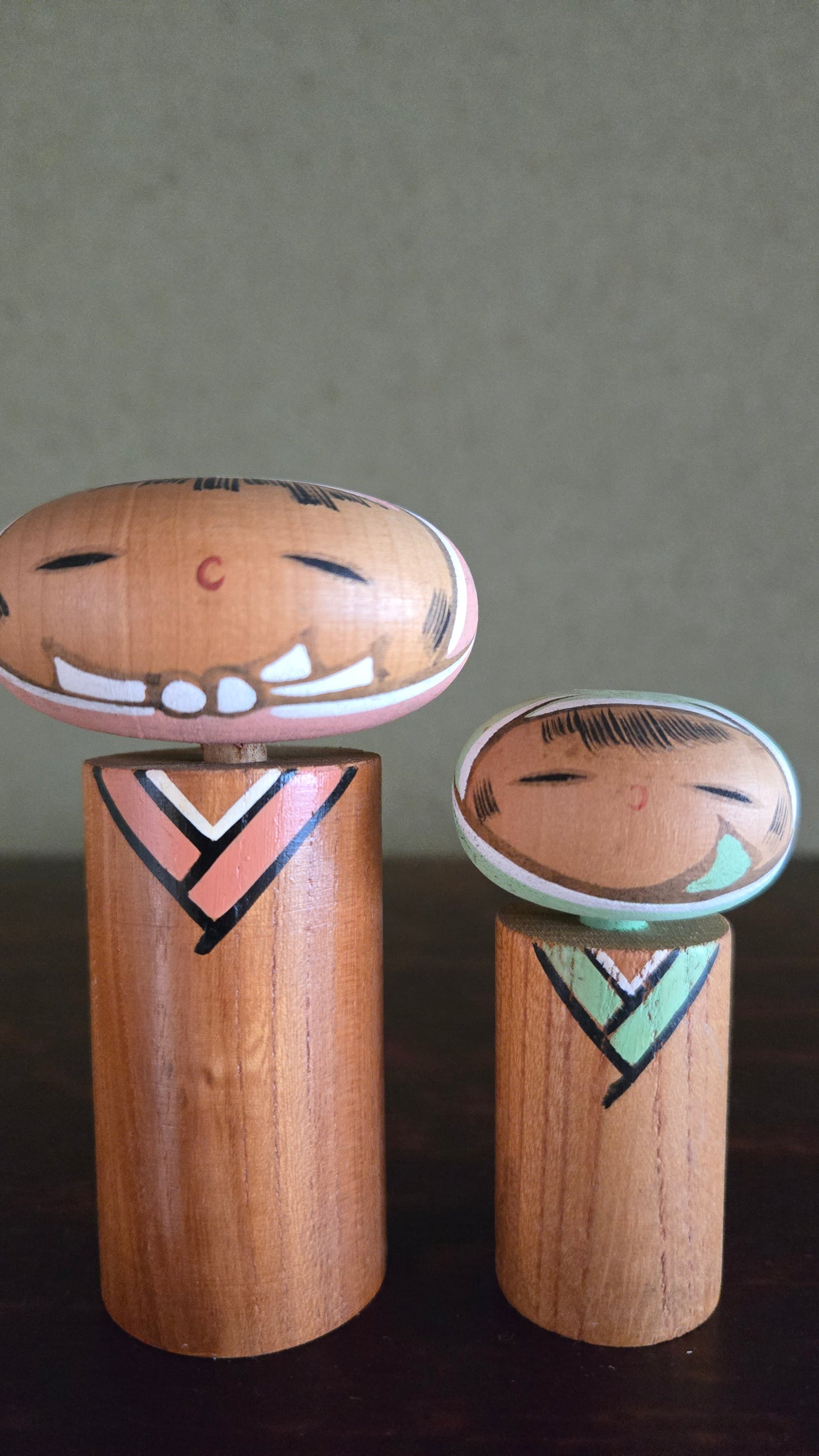 Paire de kokeshi créatives 🌸 — têtes ovales aplaties, chevrons géométriques rose & vert menthe