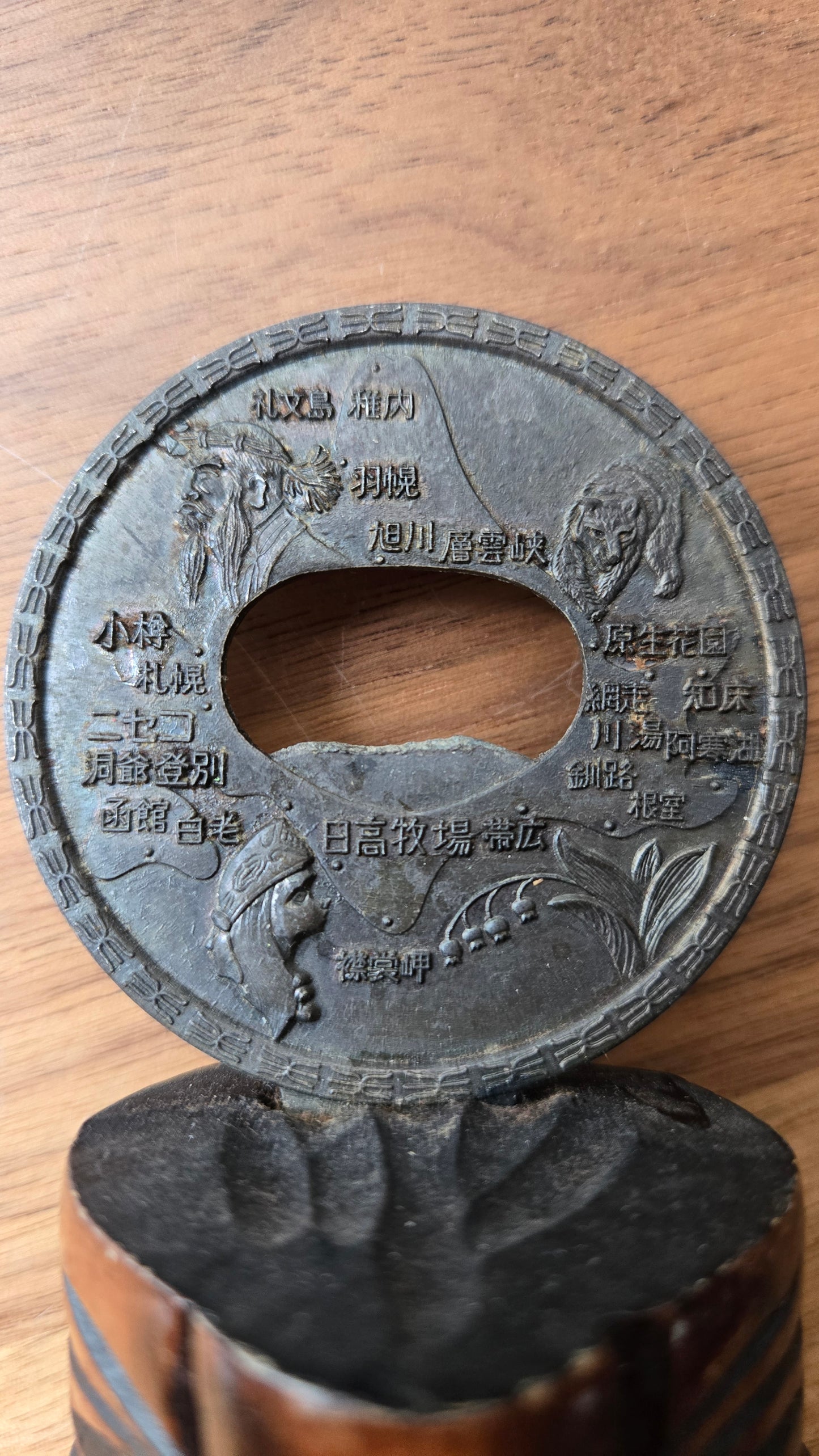 Décapsuleur souvenir Hokkaido vintage — Médaillon en métal gravé & socle bois sculpté style Aïnou