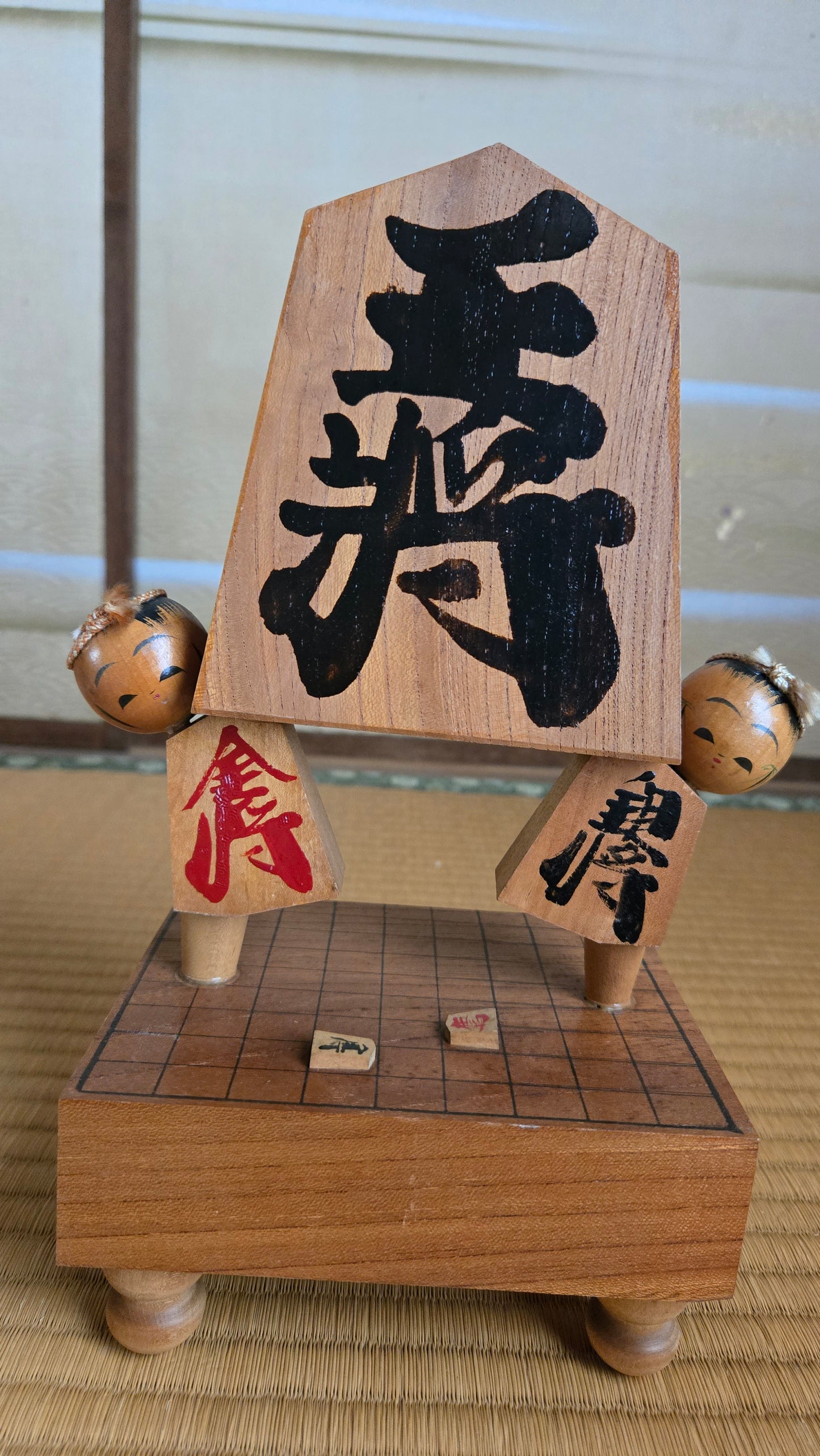♟️ Objet décoratif « pièce de shōgi géante » porté par deux kokeshi