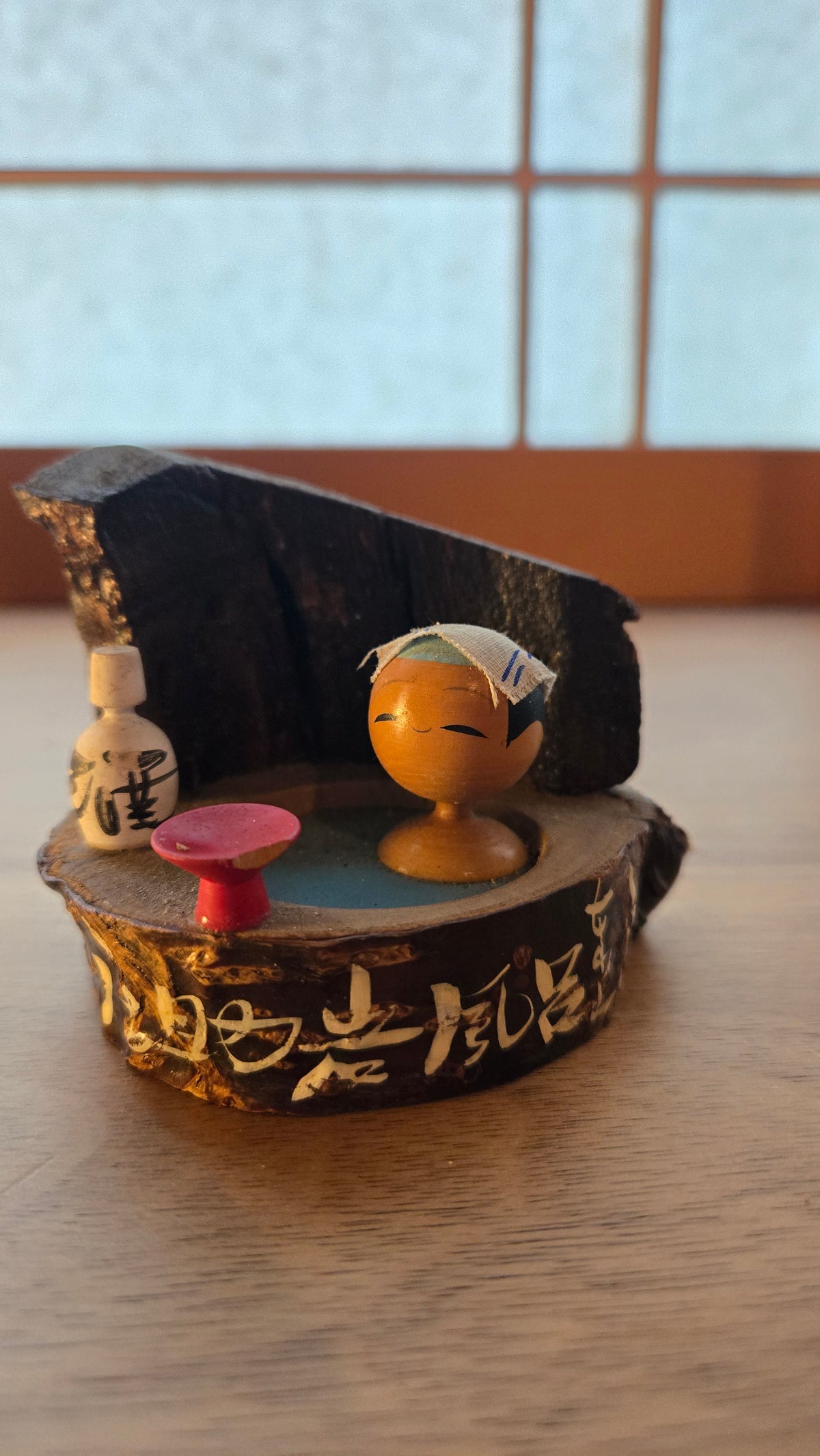 🪆 Kokeshi au bain – scène de rotenburo avec saké, sur tranche de bois