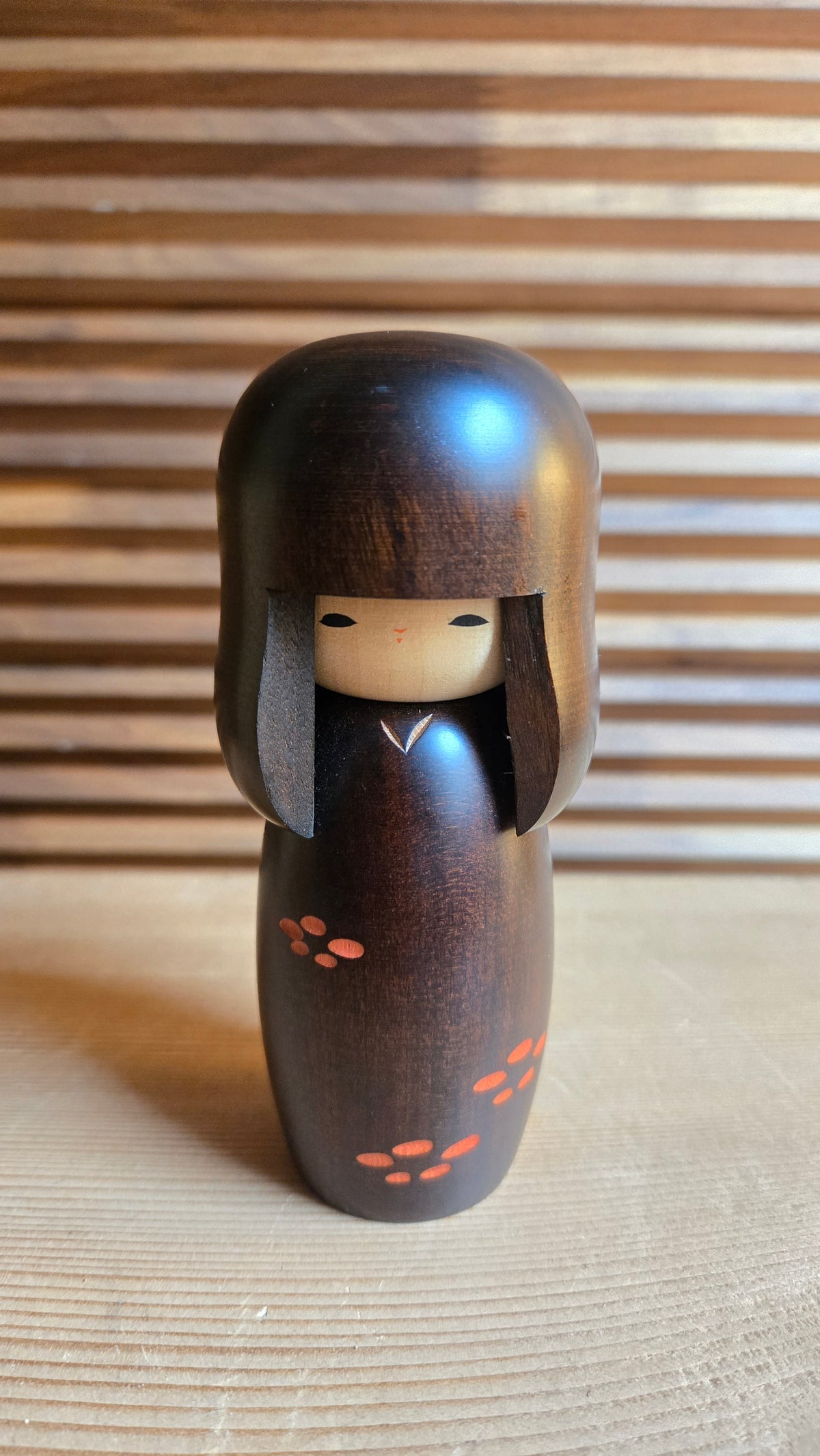 🎎 Kokeshi sōsaku en bois teinté brun – cheveux sculptés et petites fleurs orange