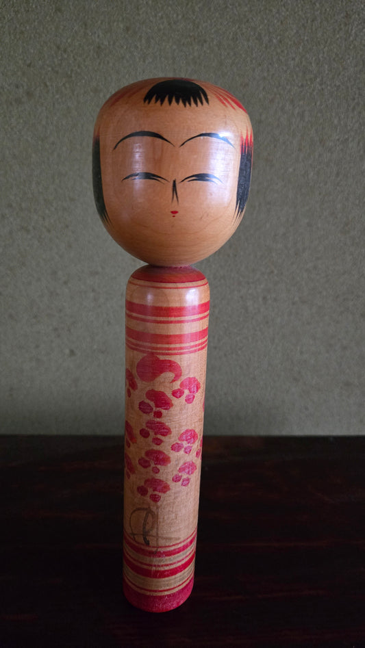 🎎 Kokeshi traditionnelle — cascade de fleurs et anneaux rouges