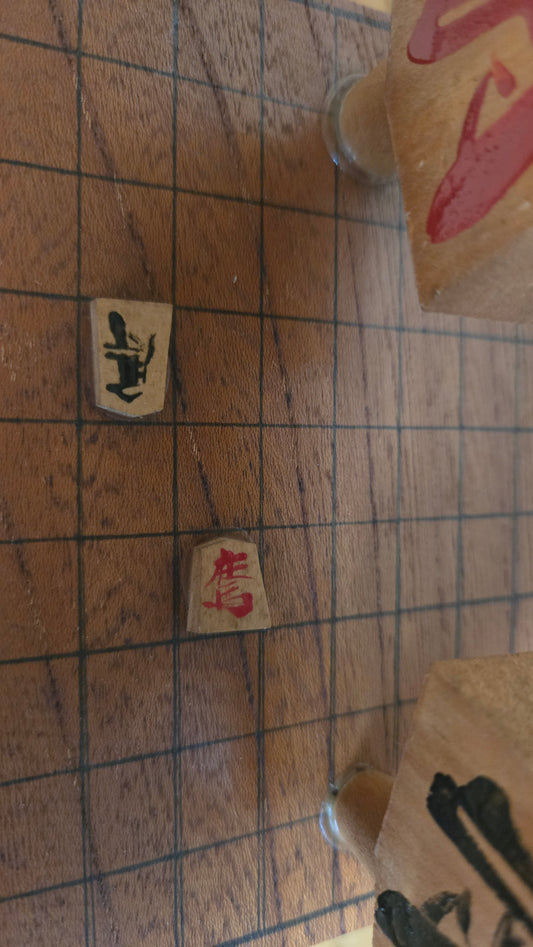 ♟️ Objet décoratif « pièce de shōgi géante » porté par deux kokeshi