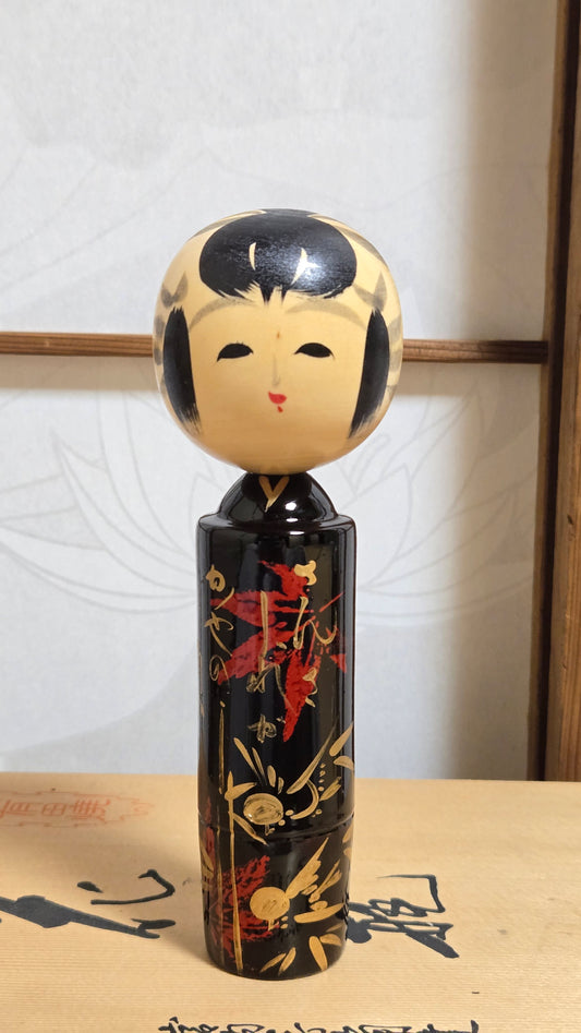🎋 Kokeshi laquée noire au visage de geisha — motif de nandina rouge et or, signature d'artisan