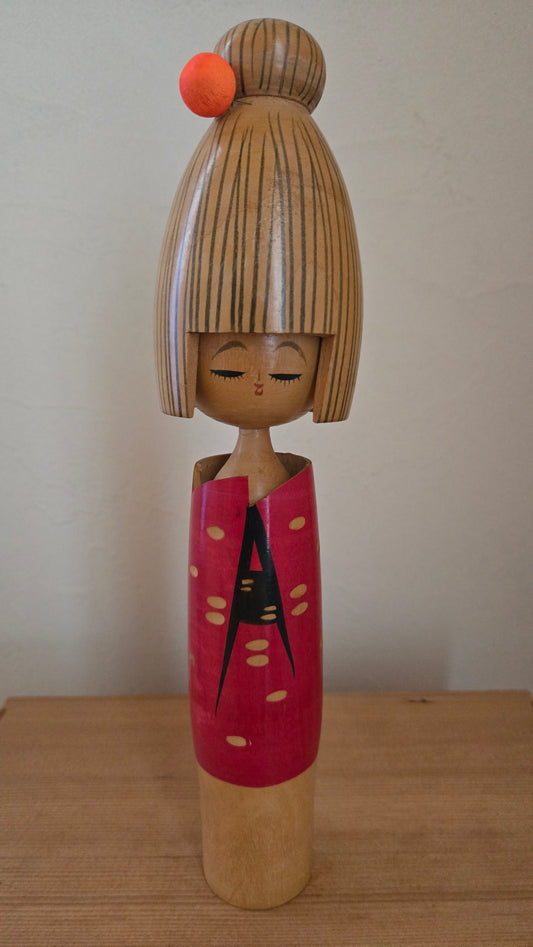 🎎 Kokeshi sōsaku, 27 cm — coiffure à chignon relevé, pompon orange, cachet rouge à la base