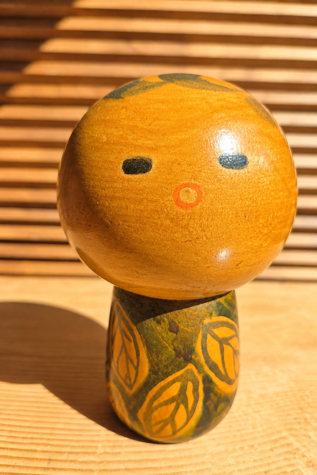 🎎 Kokeshi sosaku à tête ronde et petite bouche orange – motif de feuilles