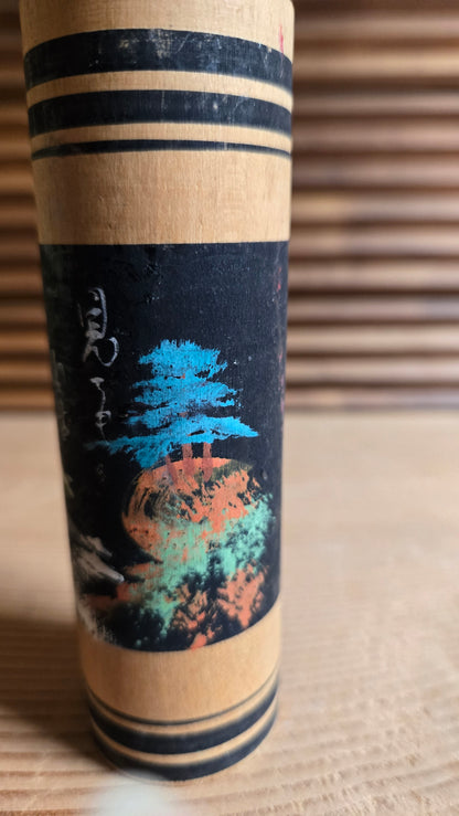 🎎 Kokeshi sōsaku à scène de paysage peinte sur fond noir, pin bleu et soleil orange