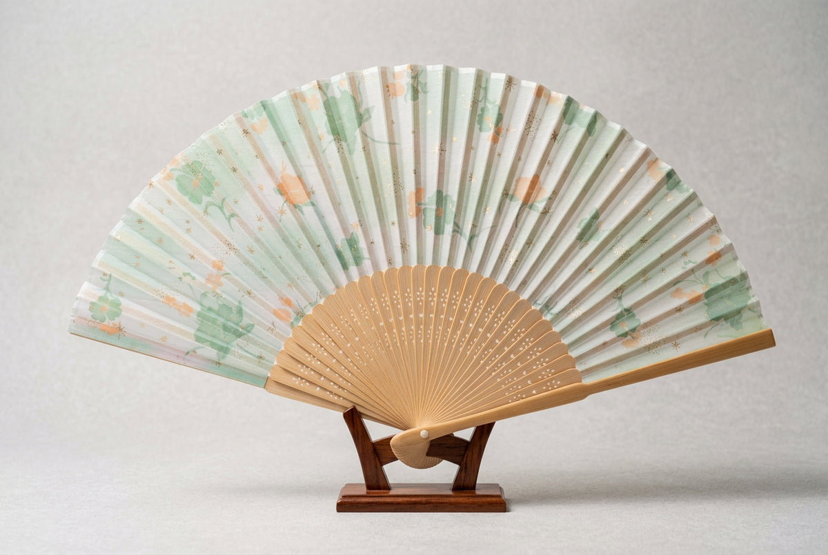 Éventail pliant japonais en tissu – fleurs vertes et orangées, étoiles dorées, lames ajourées